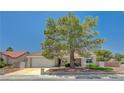 Attractive home exterior with a large tree in the front yard, two-car garage, and easy access to nearby neighborhoods at 8813 Sundial Dr, Las Vegas, NV 89134