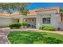 Well-manicured front yard featuring desert landscaping, a green lawn, and comfortable seating on the front patio at 8813 Sundial Dr, Las Vegas, NV 89134