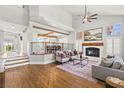 Bright living room with hardwood floors, fireplace, ceiling fan, and staircase at 8820 Fall Green Ave, Las Vegas, NV 89129