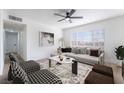 Bright living room with stylish furnishings, modern ceiling fan, and a large window offering natural light at 2 Utah Way, Henderson, NV 89015