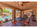 Covered patio with stone pillars, outdoor kitchen, seating area and view of the pool and garden at 3085 Duneville St, Las Vegas, NV 89146