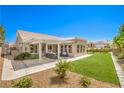 Inviting backyard showcasing a covered patio, lush lawn, manicured landscaping, and a serene outdoor living space at 3101 Hayden Ct, Las Vegas, NV 89134