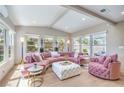 Cozy sitting room featuring a pink sectional sofa, white ottoman, and a view of the beautifully landscaped yard at 3101 Hayden Ct, Las Vegas, NV 89134