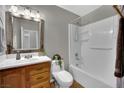 Bathroom featuring a shower-tub combo, single sink vanity, and framed mirror at 317 Kane Ave, Las Vegas, NV 89110