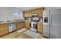 Traditional kitchen with stainless steel appliances, light wood cabinets, and tile backsplash at 317 Kane Ave, Las Vegas, NV 89110
