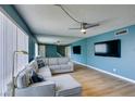 Spacious living room with sleek wood floors, modern lighting, and comfortable sofa with blue accents at 3785 Decade St, Las Vegas, NV 89121