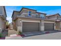 Attractive two-story townhome featuring attached two-car garage, neutral stucco, and well-kept landscaping at 4533 Queens Hill St, North Las Vegas, NV 89031