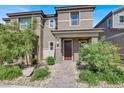 Beautiful exterior view of home with a brown front door and low maintenance desert landscaping at 4533 Queens Hill St, North Las Vegas, NV 89031