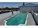 Rectangular swimming pool with clear blue water surrounded by a gray patio and greenery, providing a relaxing outdoor space at 4600 Paradise Rd # 16, Las Vegas, NV 89169