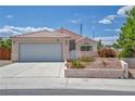 Single-story home with a tile roof, desert landscaping, and a large driveway leading to a two-car garage at 5139 Zapata Ln, North Las Vegas, NV 89031