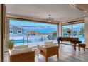 Bright living room featuring modern decor, a piano, and expansive views of the outdoor pool and neighborhood at 5438 Sierra Brook Ct, Las Vegas, NV 89149