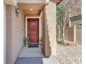 Inviting front entrance featuring a classic door, textured walls, and landscaping, enhancing curb appeal at 6068 Conroe Ct, Las Vegas, NV 89118