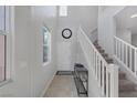 Bright foyer featuring tile flooring, staircase with white railings, and a gray console table at 7720 Houston Peak St, Las Vegas, NV 89166