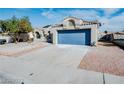 Single-story home featuring a blue garage door and a paved driveway with desert landscaping at 849 Brahma Ln, Henderson, NV 89002