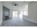 Bright living room featuring wood flooring, a fireplace with decorative paneling, and sliding glass doors at 849 Brahma Ln, Henderson, NV 89002