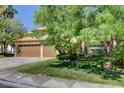 Well-maintained home with a green lawn and mature trees, featuring a three-car garage and terracotta roof at 902 Cripple Creek Ct, Henderson, NV 89014
