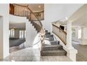 Elegant foyer showcasing a curved staircase with wooden railings and views of the living spaces at 902 Cripple Creek Ct, Henderson, NV 89014