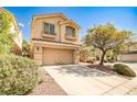 Traditional two-story home featuring a two-car garage, neutral stucco, and tidy front yard landscaping at 9122 Mountain Maple Ct, Las Vegas, NV 89148