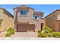 Two-story home featuring a two-car garage, desert landscaping, and a charming arched window at 106 Rock Crossing Ave, North Las Vegas, NV 89031
