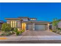 Attractive single-story home at dusk with a two-car garage, desert landscaping, and neutral color scheme at 12295 Skyracer Dr, Las Vegas, NV 89138