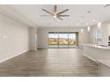 Open living area with wood-look tile flooring, fan and large sliding glass doors providing backyard views at 12550 Point Sierra St, Las Vegas, NV 89138