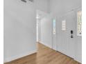 Clean entryway showcasing white walls, wood floors, and a front door with decorative glass panels at 1795 Nuevo Rd, Henderson, NV 89014