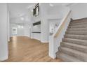 Bright living room boasting vaulted ceilings, and staircase with plush carpet, with wood flooring throughout main area at 1795 Nuevo Rd, Henderson, NV 89014