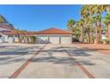 Spacious home featuring a long driveway and a sizable 3-car garage with a red tile roof and lush landscaping at 2868 Vista Del Sol Ave, Las Vegas, NV 89120