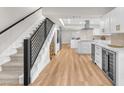 Modern kitchen featuring sleek white cabinetry, stainless steel appliances, and a staircase with black metal railings at 2868 Vista Del Sol Ave, Las Vegas, NV 89120