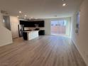 Bright living space with wood-look floors, sliding glass doors to the backyard, and modern kitchen at 4266 Yucca Brevi Ave, Las Vegas, NV 89139