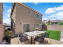 Spacious backyard featuring a patio with seating, a green lawn, and privacy fencing, perfect for entertaining at 5616 Canoe Ridge Ct, Las Vegas, NV 89141