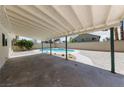 A covered patio area with view of the backyard oasis that features a refreshing swimming pool at 6999 Montcliff Ave, Las Vegas, NV 89147