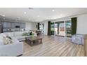 Bright, open-concept living space with wood-look floors, and a seamless transition to the dining and kitchen areas at 10095 Ferton Lake Ave, Las Vegas, NV 89178