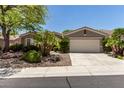 Charming single-story home featuring desert landscaping, a well-maintained lawn, and an attached two-car garage at 10463 Luna Magico Ave, Las Vegas, NV 89135