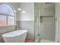 Elegant bathroom featuring a freestanding tub, arched window, and glass enclosed shower with gold fixtures at 2107 Fountain Springs Dr, Henderson, NV 89074