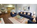 A staged living room features contemporary furniture, an open floor plan, and hardwood floors at 2615 W Gary Ave # 2061, Las Vegas, NV 89123