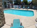 Community pool area with lounge chairs, clear blue water, and well-maintained patio area for relaxing at 2750 S Durango Dr # 2141, Las Vegas, NV 89117