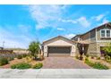 A cozy single-Gathering home with a brick driveway and desert landscaping in a tranquil suburban setting at 2845 Mincio St, Henderson, NV 89044