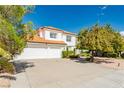 Two-story home with a three-car garage, red tile roof, and mature landscaping at 2920 Sterling Cove Dr, Las Vegas, NV 89128