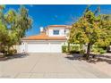 Two-story home with a three-car garage, red tile roof, and xeriscape yard at 2920 Sterling Cove Dr, Las Vegas, NV 89128