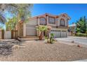 Attractive two-story house with a three-car garage, tile roof, and desert landscaping at 4542 Amber Canyon Ln, Las Vegas, NV 89129