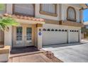 Close up of a two-story home featuring a three-car garage and a tiled entryway with security at 4542 Amber Canyon Ln, Las Vegas, NV 89129