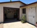 View of open garage and secured utility door, with outdoor plants at 462 Crestway Rd, Henderson, NV 89015
