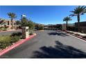 Gated entrance to a community with palm trees and well-maintained landscaping at 49 Charlotte Ridge Pl, Henderson, NV 89011