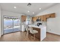 Modern kitchen features an island with seating, stainless steel appliances, and sliding glass doors at 4911 Ranchodomingo Ct, North Las Vegas, NV 89031