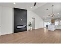 Bright living room featuring wood flooring, a modern fireplace, and an open layout to the kitchen at 4911 Ranchodomingo Ct, North Las Vegas, NV 89031