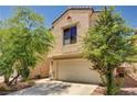 Two-story home with a two-car garage and landscaping that includes small trees and green shrubs at 5220 Melbourne Ridge Ct, Las Vegas, NV 89141