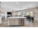 Open-concept kitchen with stainless steel appliances, an island, and a seamless flow to the living and dining area at 5220 Melbourne Ridge Ct, Las Vegas, NV 89141