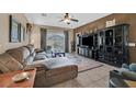 Cozy living room with tile flooring, ceiling fan, and a sliding glass door at 6141 Tokara Ave, Las Vegas, NV 89122