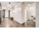 Welcoming home foyer featuring modern lighting, and stylish accent wall, and beautiful, dark wood-look flooring at 6233 Canterbury Field Rd, Las Vegas, NV 89113